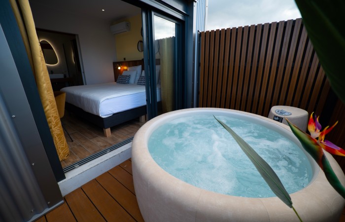 Chambre Bananier avec jacuzzi : Supérieure
Bienvenu dans votre chambre Bananier de 14 m2 + 10 M2 de terrasse avec jacuzzi privé et situé au 2e étage. Ambiance exotique et relaxante. Prélassez-vous et savourez cette bulle de bien-être aux nuances douces et naturelles. Son lit King Size et sa salle de bain moderne aux teintes minérales apportent une touche de confort supplémentaire qui sublimeront votre séjour.
En savoir plus
Reserver au meileur prix